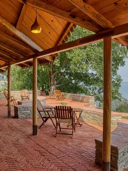 The expansive veranda with its concentric brick flooring and simple wooden furniture provides a perfect spot to relax and take in the stunning valley views.