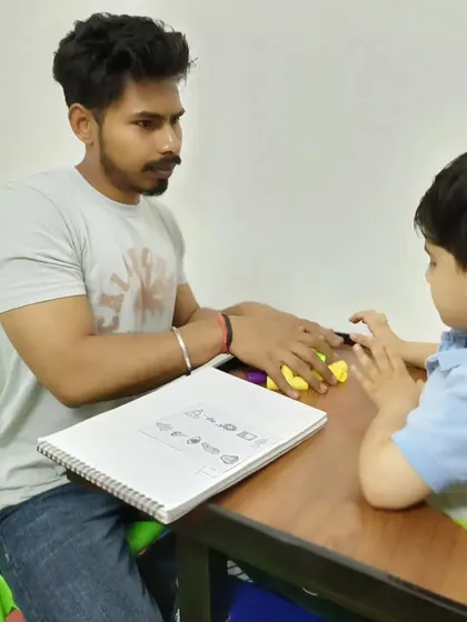 In our special education sessions, we focus on foundational academic skills. Here, a therapist works with a child on pre-writing exercises using tactile materials to improve grip and cognitive understanding before moving to paper.