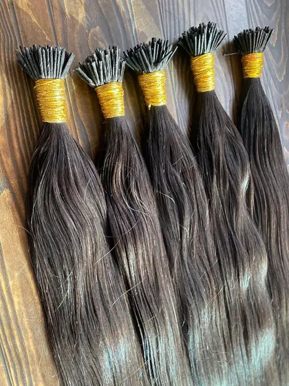 Bundles of our straight I-Tip extensions, neatly bound with gold thread. This shows the quality and care we put into preparing our products for salons and stylists.
