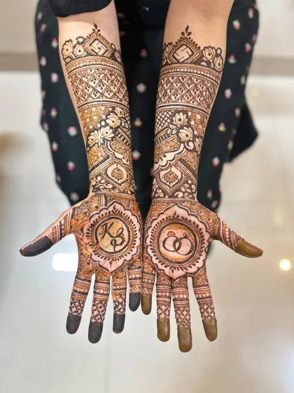 The engagement mehendi for Kasturi, featuring her and her partner's initials and engagement rings.