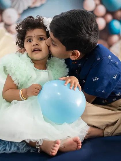 A sweet kiss between siblings. Capturing these moments of affection is what makes sibling photoshoots so special and heartwarming.
