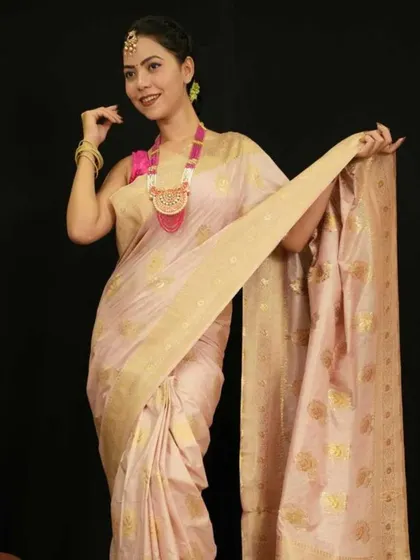 A model in a beautiful silk saree wears a long, statement necklace with a large pink pendant.