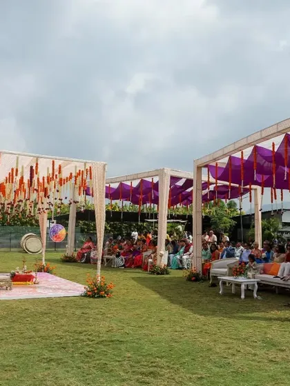 An outdoor Haldi ceremony setup with vibrant purple and orange drapes. This wide view shows the festive and colorful atmosphere we created for Sonam and Ross's celebration.