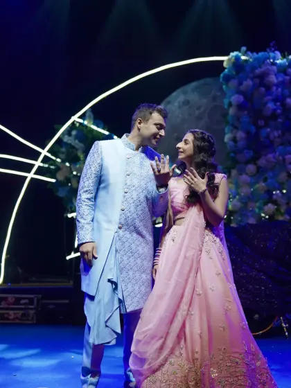 A sweet, candid moment between the engaged couple on stage, lost in their own world.