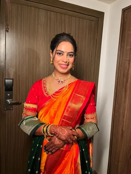 The complete look of the Marathi bride, showcasing the beautiful drape of the Nauvari saree and the traditional jewelry. The makeup is elegant and timeless.