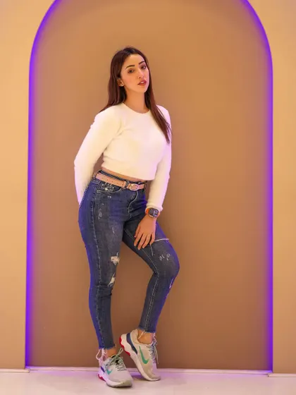 A full-body pose demonstrating a casual but confident look.