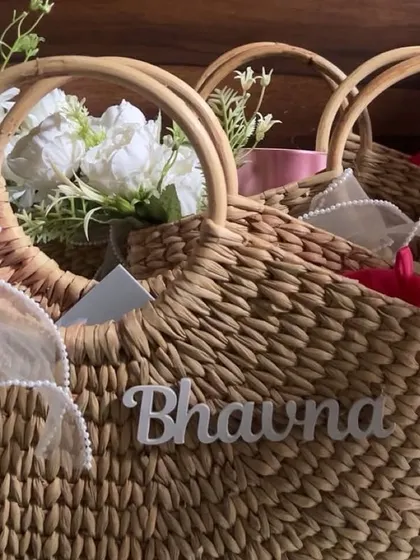 A closer look at the personalized wicker bags for bridesmaids. Each bag is adorned with the bridesmaid's name, a floral touch, and a beautiful ribbon.