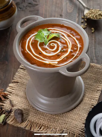A beautifully styled bowl of Dal Makhani. The swirl of cream on top is the focal point, created carefully to add an artistic touch to the dish.