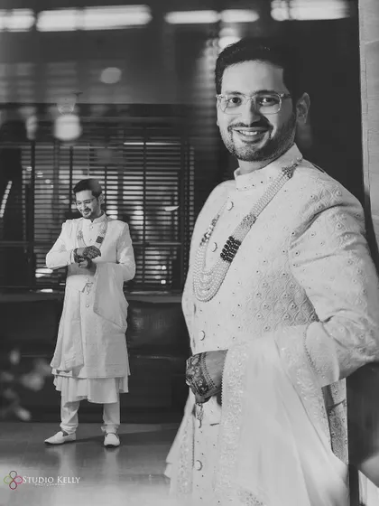 A black-and-white shot of the groom getting ready, looking dapper and happy.