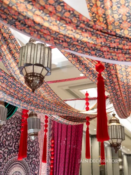 A ceiling of texture and tradition. I used printed fabrics and hanging Moroccan-style lanterns to create a rich and atmospheric overhead decor for a themed event.