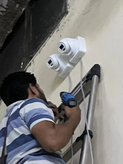 Securing the dual-camera setup to the wall. This will provide a wide field of view for monitoring a large production area.