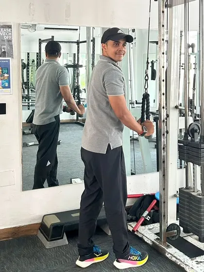 Turning to the camera while demonstrating the tricep pushdown. My focus is always on my clients, even while I train.