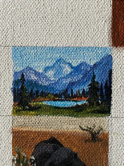 A mini-painting of a mountain landscape with a lake.