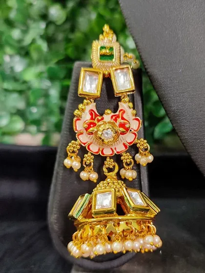 Another view of the maang tikka with floral enamel work. This close-up highlights the craftsmanship and the jhumka-style drop at the end.