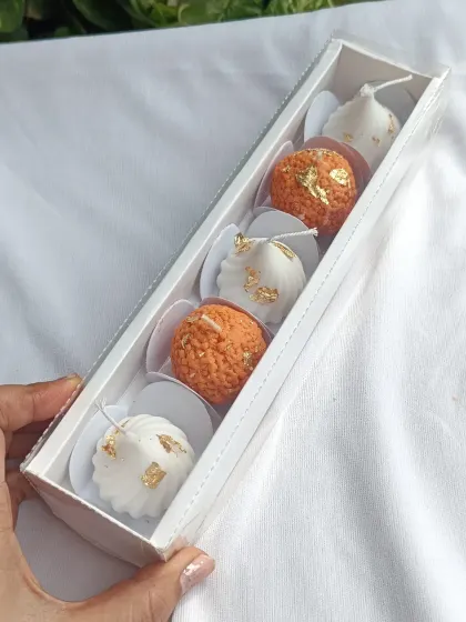 The laddoo and modak gift set, shown from an angle to highlight the 3D quality of the candles.