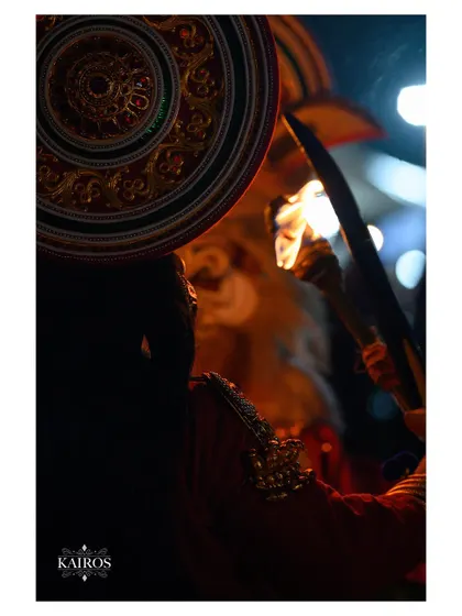 A silhouette-style shot of a performer holding a torch, where the focus is on the flame and the outline of the artist.