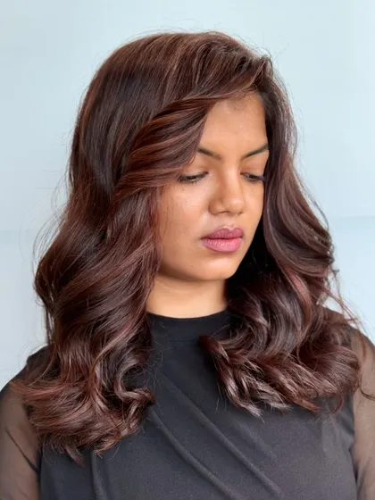 A softer, wavier take on a medium-length cut. The gentle waves and rich color create a romantic and sophisticated style.