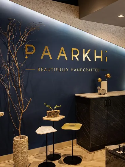A close-up of the feature wall at Paarkhi, where the brand's identity is elegantly displayed in golden lettering against a deep, signature blue. This detail shows our commitment to integrating brand elements seamlessly into the architectural design for a powerful first impression.
