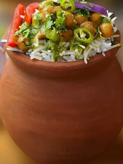 Chole Biryani served authentically in an earthen pot (matka). This method of serving not only looks great but also helps retain the flavors and aroma of the dish.