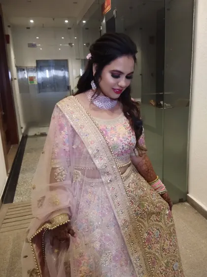 The intricate details of the lehenga are matched with soft pink and rose gold makeup tones.