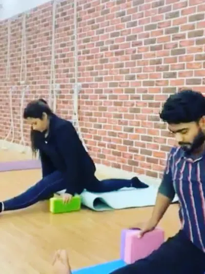 Students working on their Hanumanasana (splits) preparation using blocks for support. This gradual approach helps to open the hips safely.
