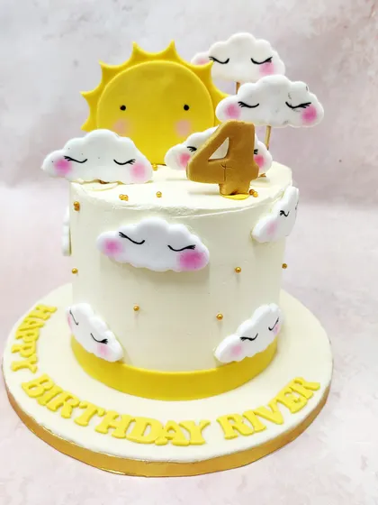 We create a sky full of sunshine with this dreamy and cheerful cake. A smiling sun peeks out from behind fluffy, sleeping clouds on a pristine white cake, making for a serene and happy fourth birthday celebration.