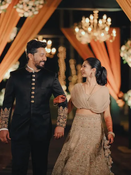 A stylish couple making their entrance at a reception with warm, elegant lighting and decor.