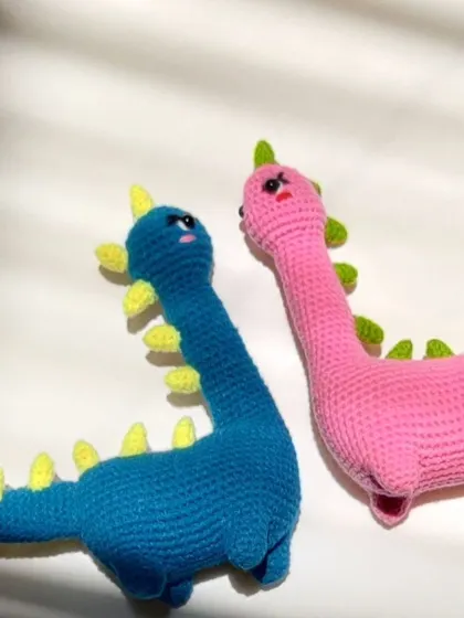 The two dinosaur plushies facing each other.