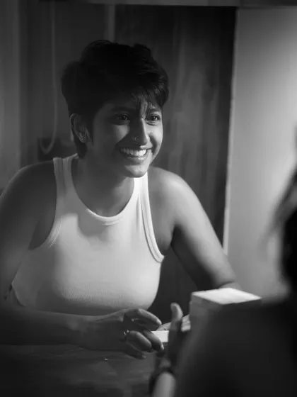 A joyful and candid black and white portrait of a woman with a wide, genuine smile, captured in conversation. This image highlights my ability to capture authentic personality and emotion.
