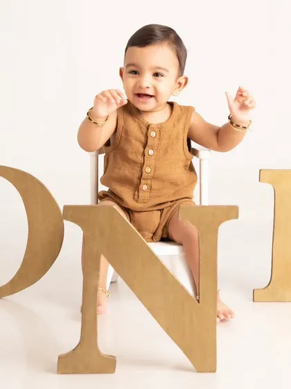 Celebrating a first birthday with a classic milestone portrait. This clean and simple setup with large "ONE" letters puts the focus entirely on your child's happy expression as they mark this special occasion.