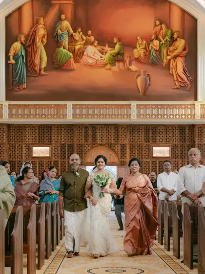 The bride being walked down the aisle by her parents. The proud and loving expressions on their faces make this a deeply touching and memorable moment.