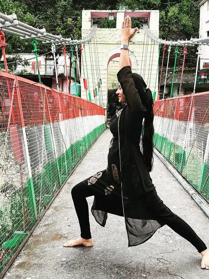 A powerful Virabhadrasana I on the iconic bridge in Rishikesh. Practicing amidst the energy and movement of this place is a reminder to find your own inner stillness, no matter the surroundings.