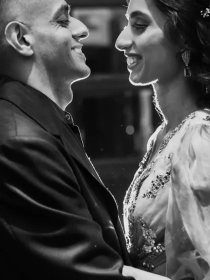 A close-up, backlit black and white shot that emphasizes the couple's smiles and silhouettes. This is a very intimate and artistic portrait.