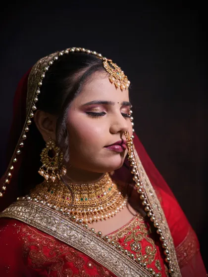 A traditional red bridal look created by one of my students. The focus is on classic elements like the maang tikka, nath, and bold red lip, showcasing their skill in creating timeless beauty.