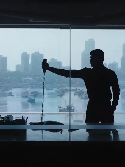 A silhouette of a shooter practicing his hold against the Mumbai skyline, blending urban life with the discipline of the sport.