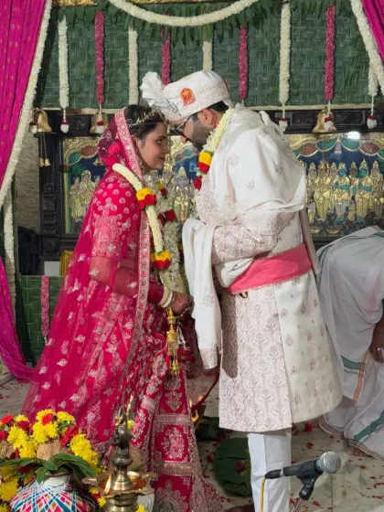 An intimate moment from a wedding ceremony inside the ashram. The traditional decor with pink drapes and floral arrangements provides a beautiful setting for the couple's sacred vows.