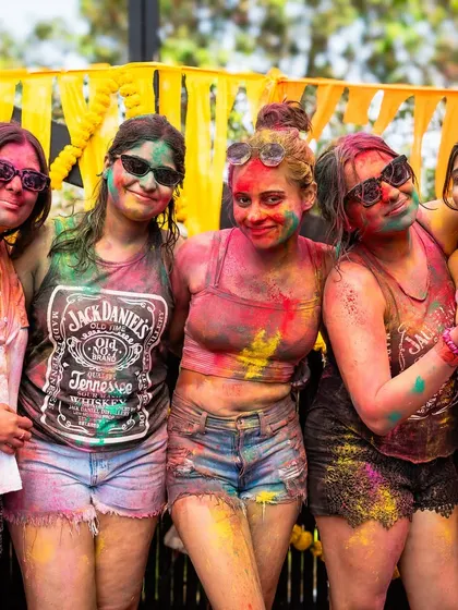 A group of friends covered in colors at our Goa Holi party. We focus on creating a fun and safe environment where everyone can enjoy the festival of colors.