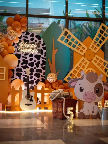 The full cowboy-themed setup, showcasing the barn, windmill, and balloon garland. This all-inclusive package provides a premium party experience with a fun, rustic twist.