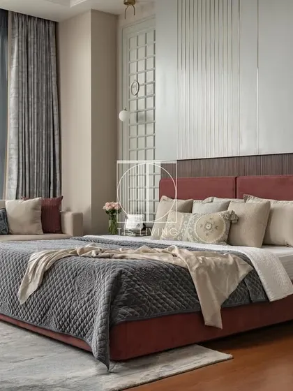 For this master bedroom, we focused on creating a layered and textured sanctuary. The custom bed with its deep red upholstery, the sleek bedside tables, and the coordinated loveseat were all crafted by us to work in harmony, resulting in a space that feels like a luxurious retreat.