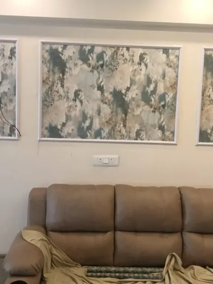 An abstract art wallpaper installed in a triptych of three panels above a sofa.