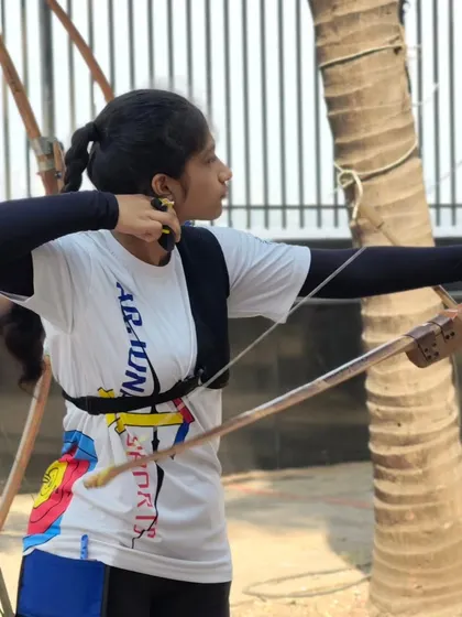 A young girl at full draw, showing strength and focus. We are building future champions.