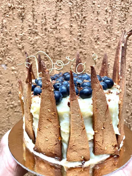 Another angle of this custom blueberry dog cake. You can see the handmade wire name topper nestled among the fresh berries.