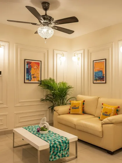 A cozy and elegant living space featuring classic wall molding and sophisticated wall sconces. The compact sofa and modern coffee table make this an ideal design for smaller apartments without sacrificing style.