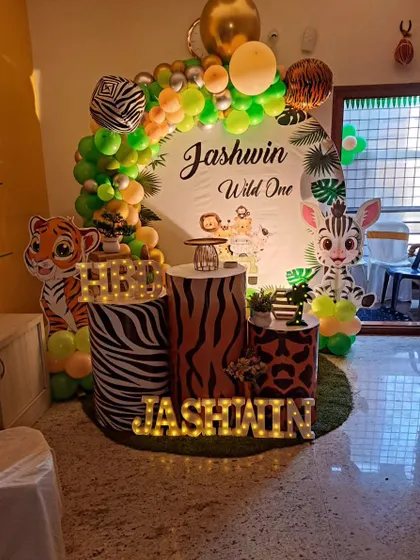 We designed this simple yet charming jungle theme for Jashwin's "Wild One" party. It features animal print pedestals, cute character cutouts, and a green and gold balloon arch, perfect for a home celebration.