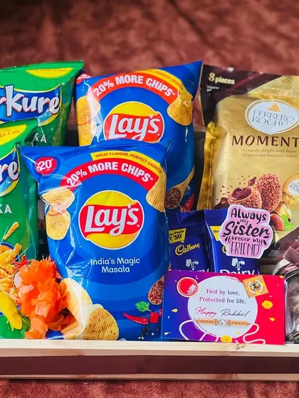 A snack-lover's dream hamper for Rakhi, loaded with packets of Kurkure, Lay's, and Ferrero Rocher Moments.