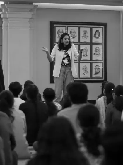 A black and white shot of me addressing a large group of college students. My goal in these workshops is to create a space where young adults can explore storytelling as a powerful tool for connection and self-expression.