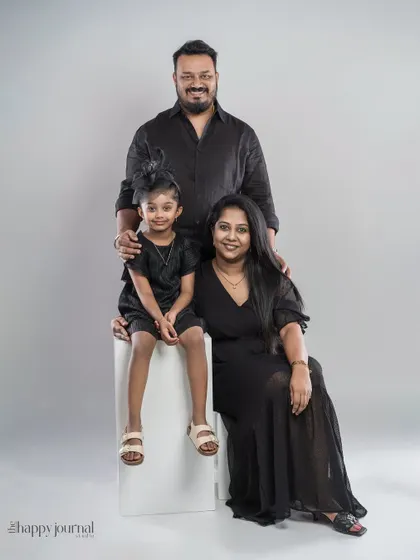 A formal family portrait in matching black outfits. This classic studio setup creates a timeless and elegant look, focusing on the family's strong presence.