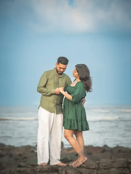 A tender pre-wedding portrait by the sea. The way he holds her hand and looks at her shows the deep connection and affection between them.