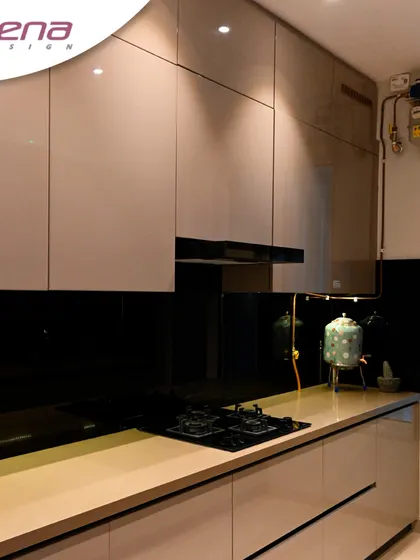 A hi-tech kitchen with handleless cabinets and a black glass backsplash for a seamless, ultra-modern appearance. The under-cabinet lighting highlights the clean lines.