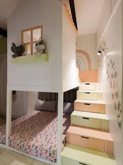 A side view of the house-frame bunk bed, showing how the storage stairs lead up to the top level. The design creates a multi-level play and sleep structure that kids absolutely love.